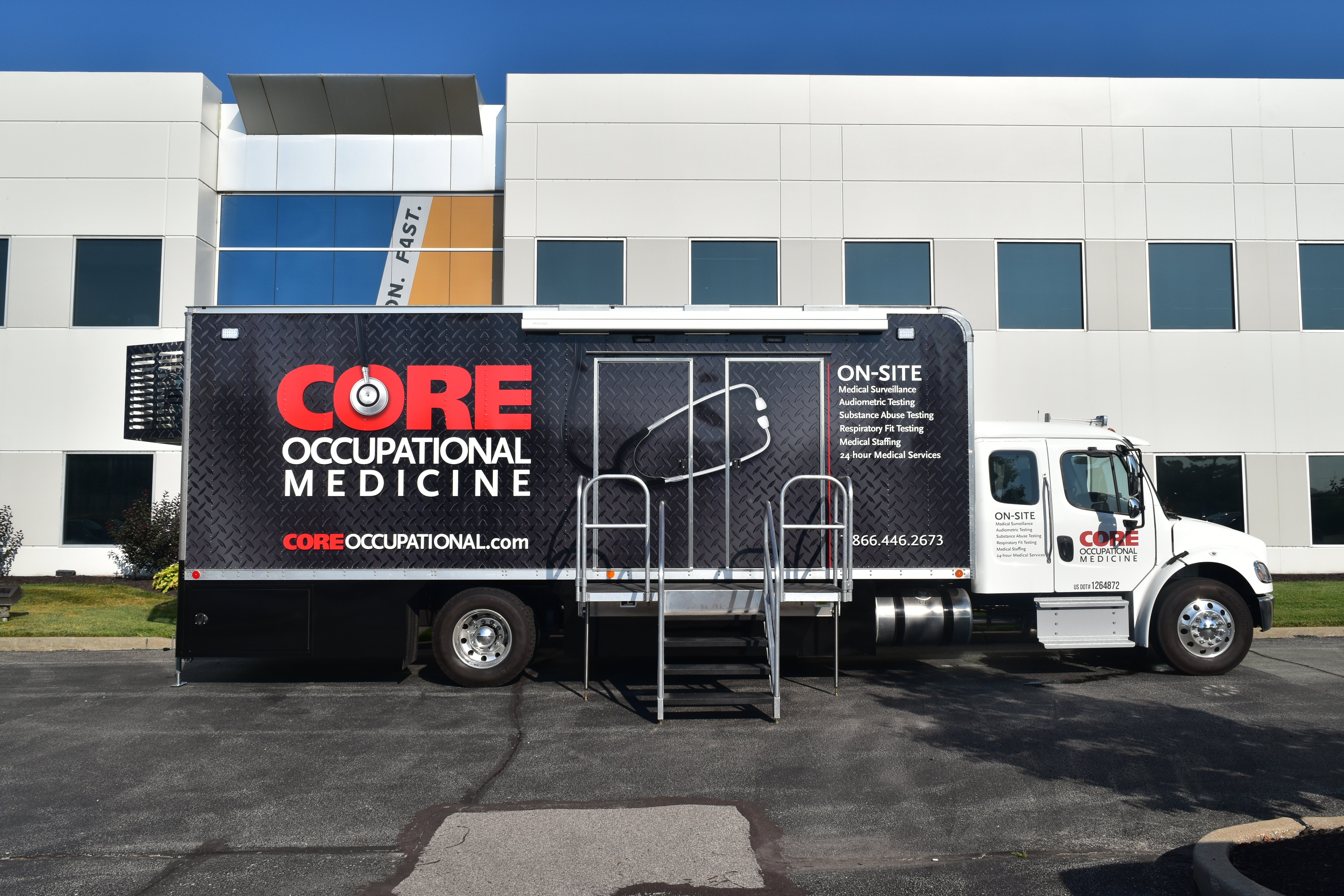 Exterior of a mobile audiometric testing van with accessibility ramp and company branding.
