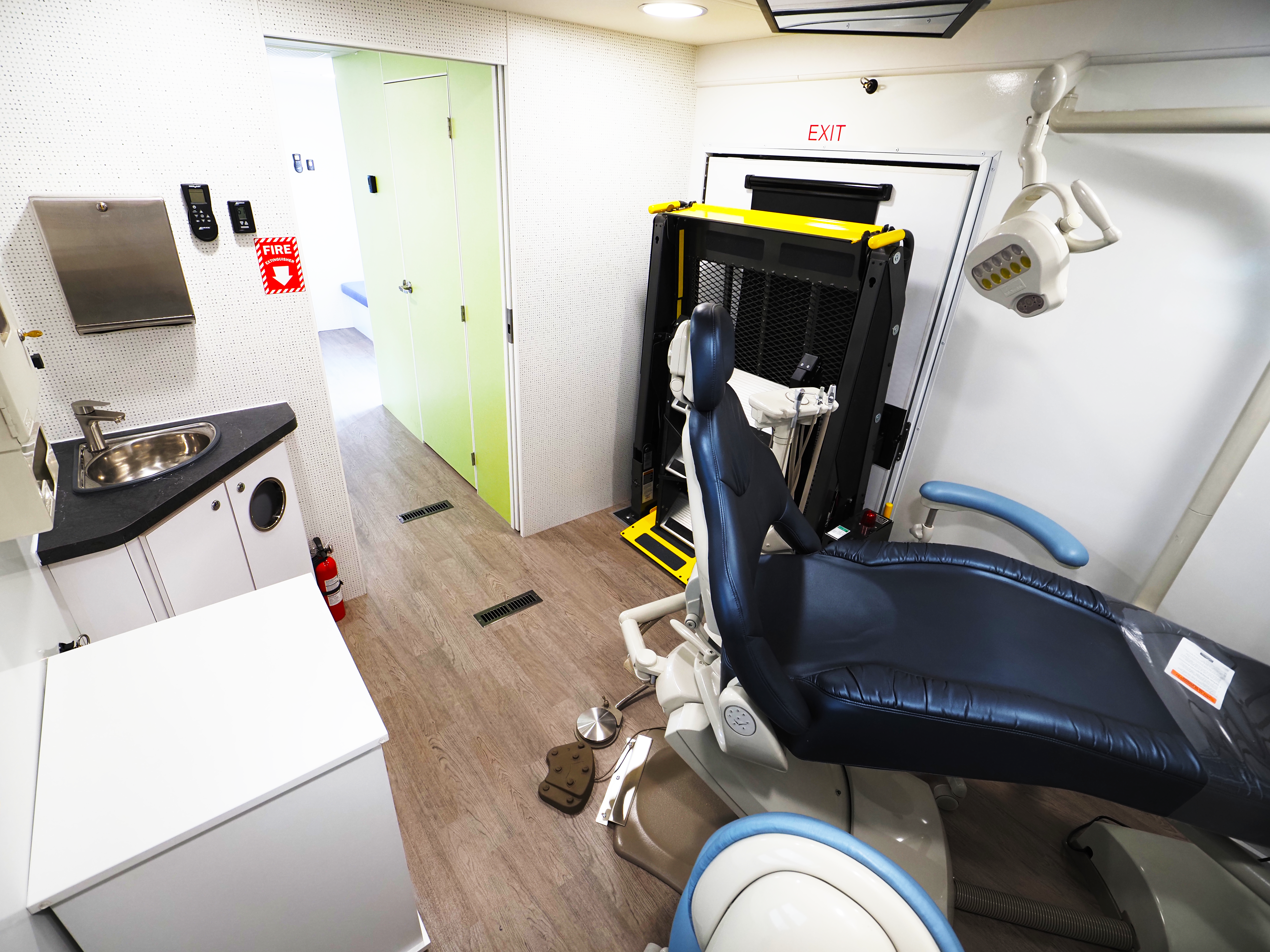Interior of a mobile dental clinic with dental chair, instruments, and sterilization area.
