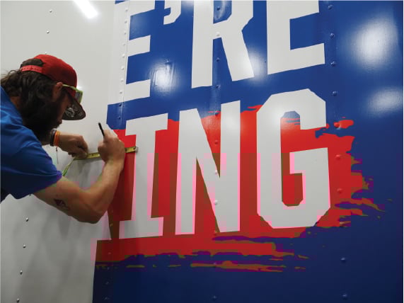 Professional installer applying high-quality cast vinyl wrap to a commercial vehicle