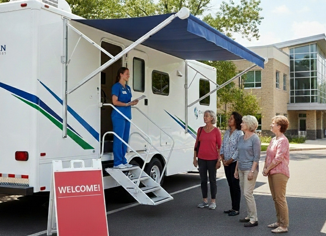 A white mobile medical outreach unit parked in a sunny lot. The vehicle features blue and green diagonal stripes on the side and a retractable black awning.