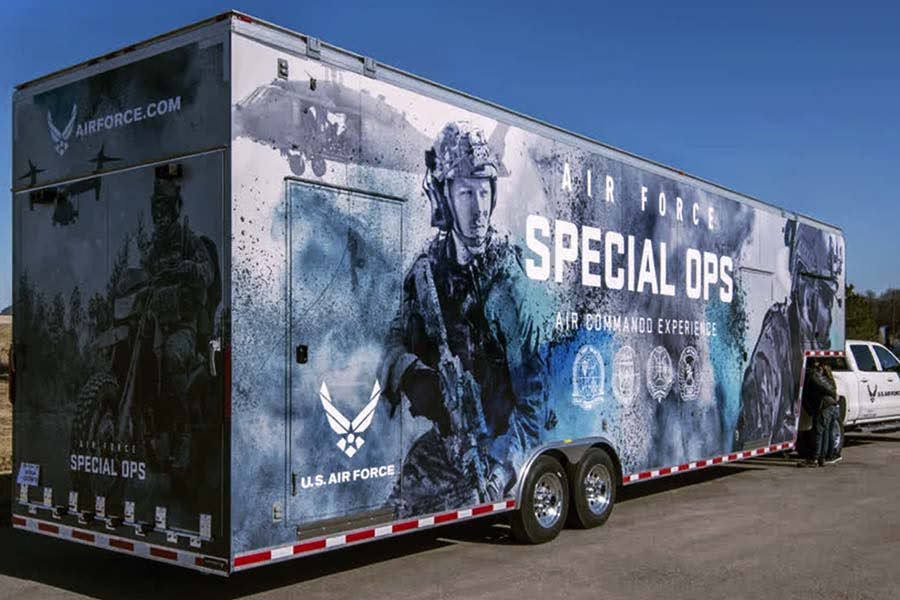 Exterior of a large U.S. Air Force Special Ops promotional trailer with a full-color graphic wrap featuring airmen in combat gear and various military insignia.