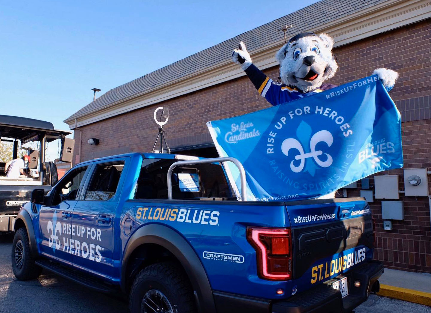 St. Louis Blues "Rise Up for Heroes" truck wrap on a blue Ford Raptor with team mascot