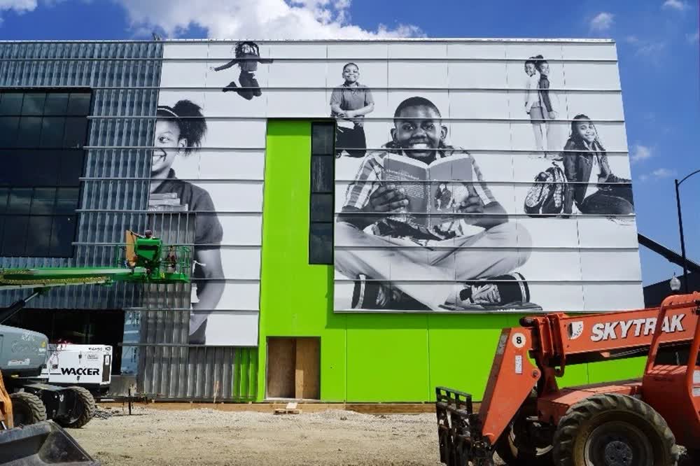 Installation of large format graphics depicting diverse students on Chicago Charter School exterior facade.
