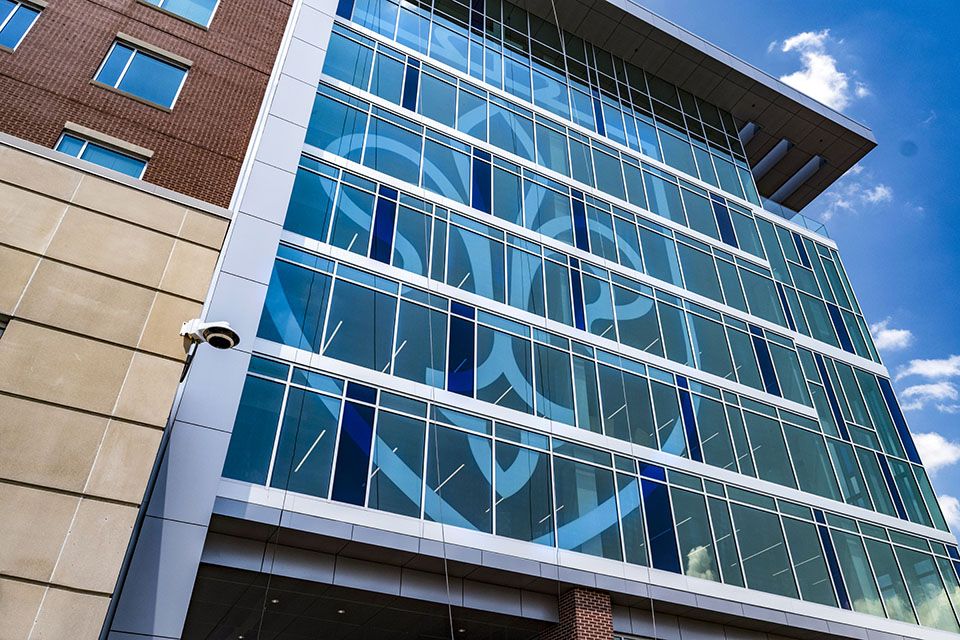 Saint Louis University (SLU) Hospital glass building exterior with large blue crest logo