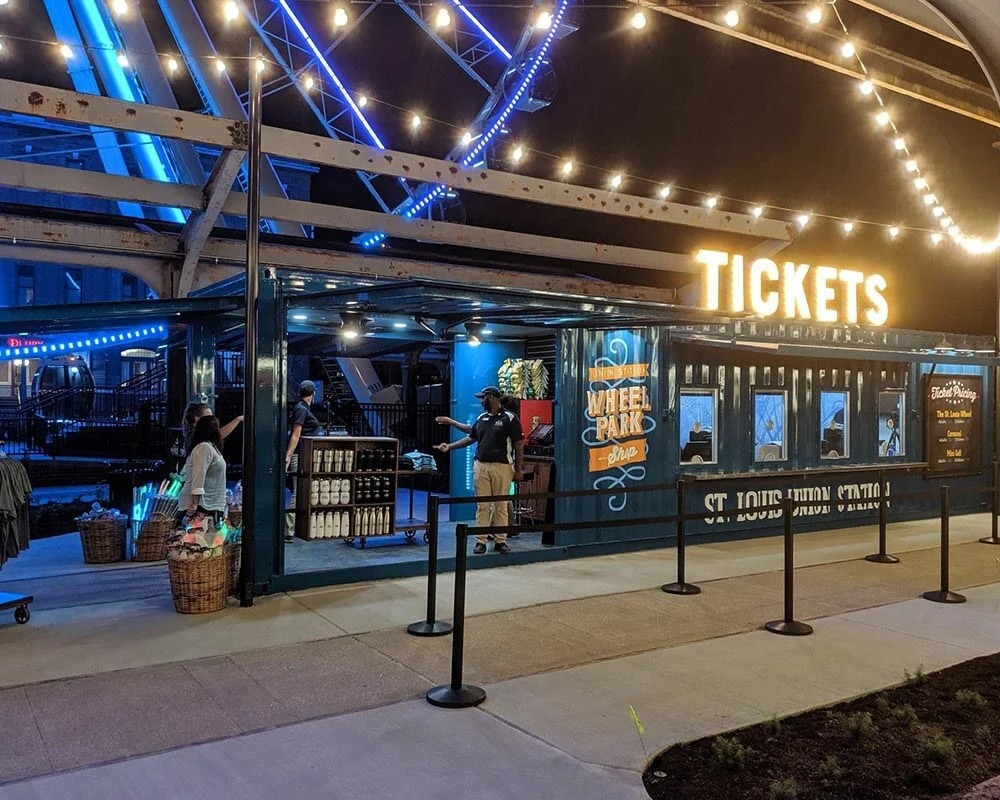 Green ticket container booth for Wheel Park and St. Louis Union Station at night.