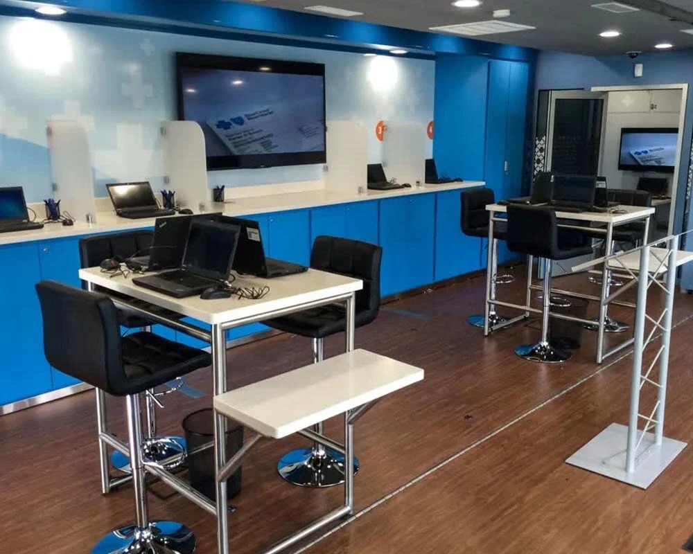 Interior view of a modern Blue Cross Blue Shield mobile command center with multiple workstations, laptops, and a large display screen.