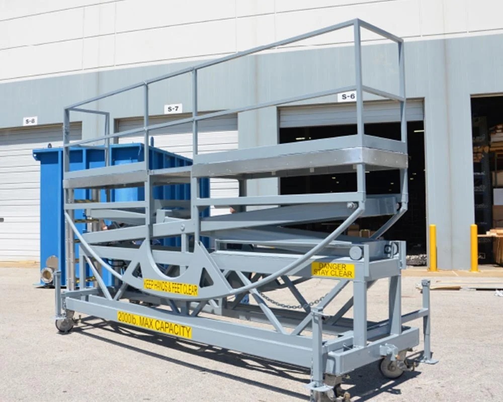 Heavy-duty industrial fabrication scissor lift platform on wheels with guardrails and a 2000lb maximum capacity warning label.