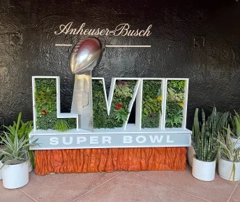 Super Bowl LVI sign with green plant lettering and Anheuser-Busch logo.