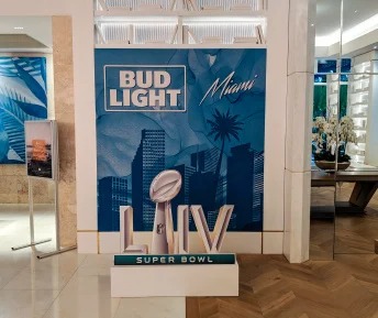 Bud Light Miami Super Bowl LIV lobby event display with large-scale branding and 3D Super Bowl trophy graphic.