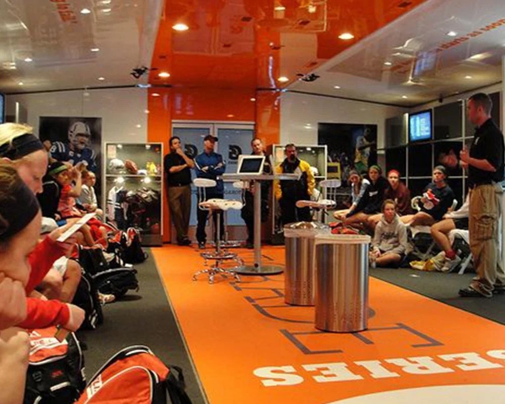 oaches and athletes attending a Gatorade sports performance seminar inside a branded training room with product displays and interactive screens
