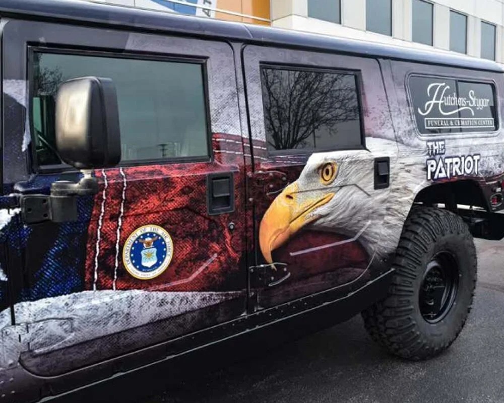 Custom patriotic vehicle wrap on Hummer H1 featuring bald eagle graphic and Hutchens-Stygar Funeral & Cremation Center branding.