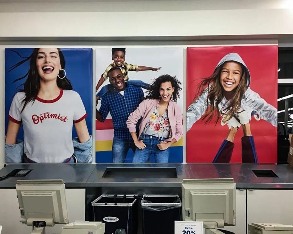 Old Navy custom vinyl graphics at a store checkout counter featuring large images of diverse smiling people