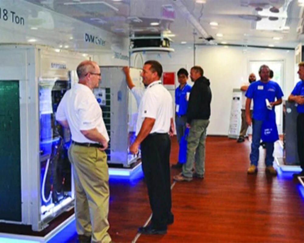 Samsung HVAC onsite mobile showroom with staff demonstrating the DVM Chiller unit to attendees.