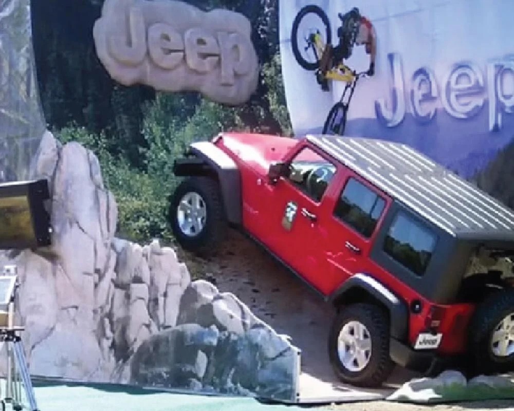 Jeep brand experiential marketing display showing a Wrangler on a simulated off-road course with large graphics.