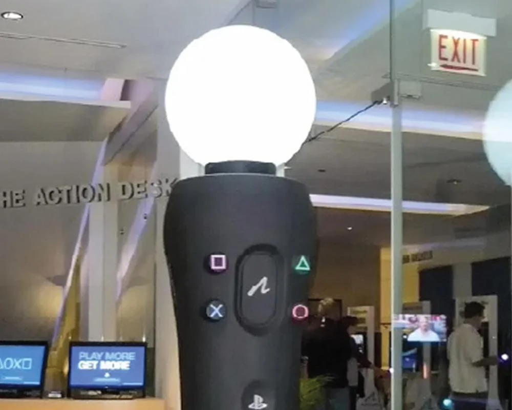 Oversized display replica of the Sony PlayStation Move controller with glowing white orb and face buttons.
