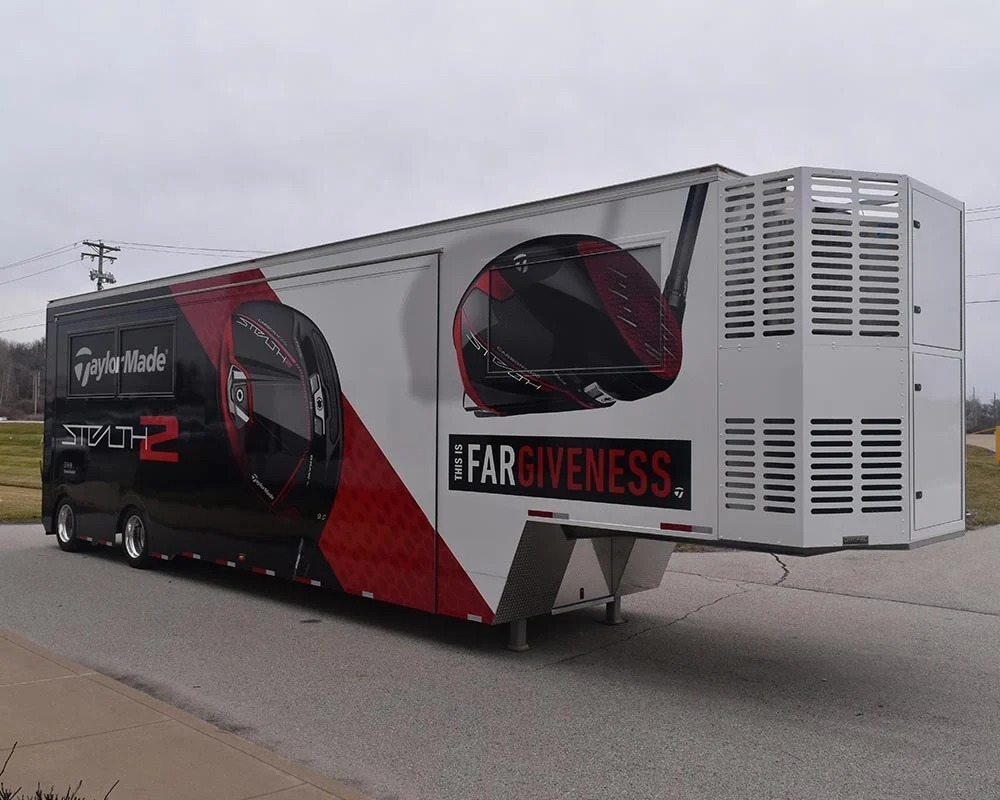 TaylorMade Stealth 2 logo and graphic on a large semi-trailer parked roadside.