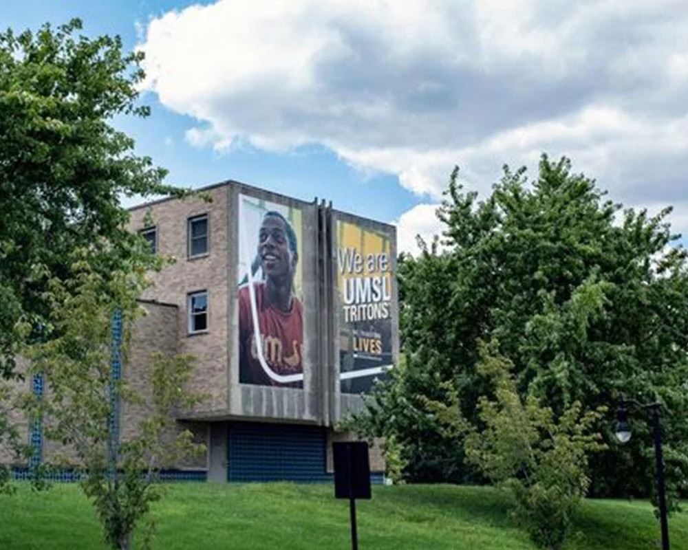 Exterior building graphics on UMSL campus featuring student