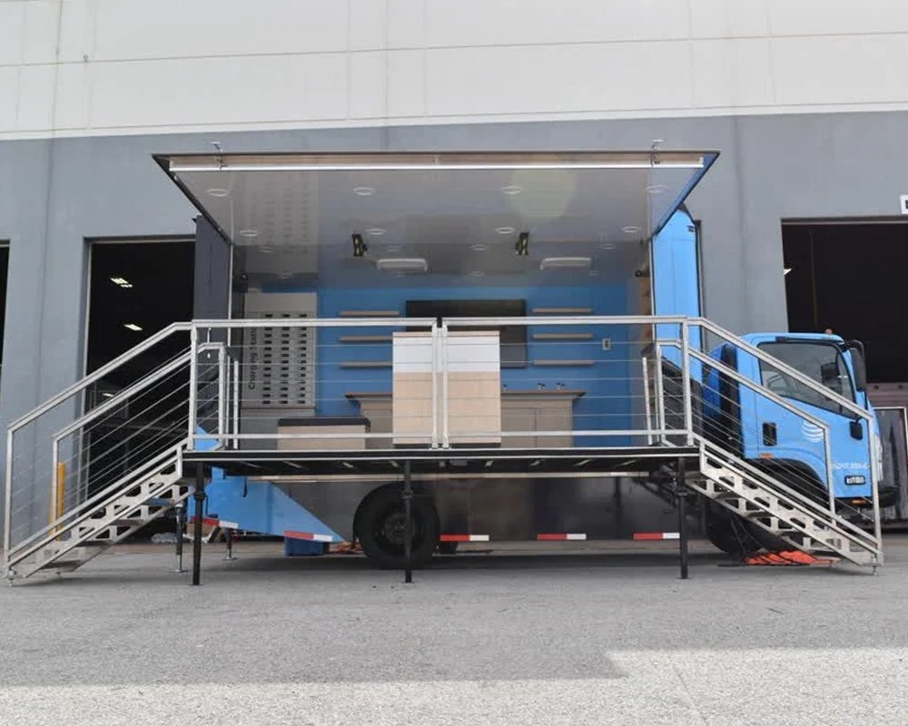 AT&T mobile showroom trailer with a blue interior, viewing deck, dual staircases, and a promotional truck cab attached.