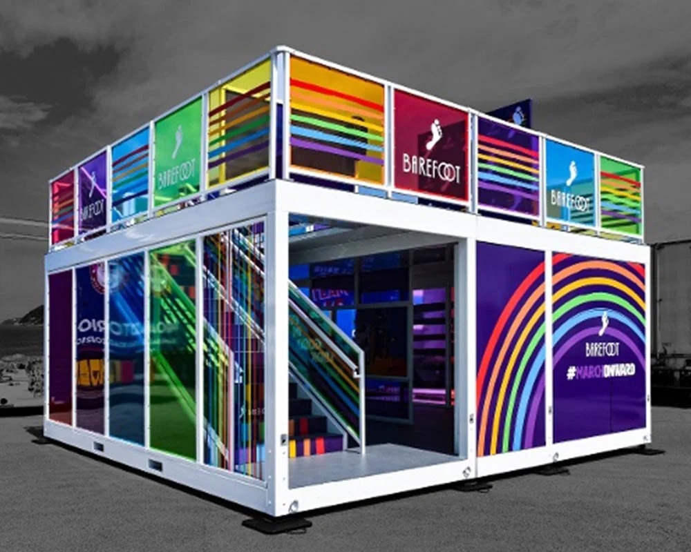 Barefoot Wine two-story shipping container booth with rainbow-colored windows for a small experiential event.