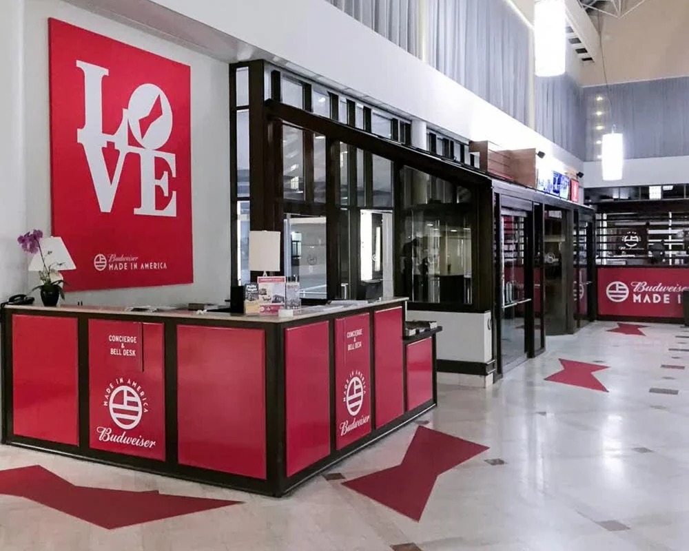 Budweiser Made In America Concierge Bell Desk and LOVE sign graphic in stadium club level or premium area.