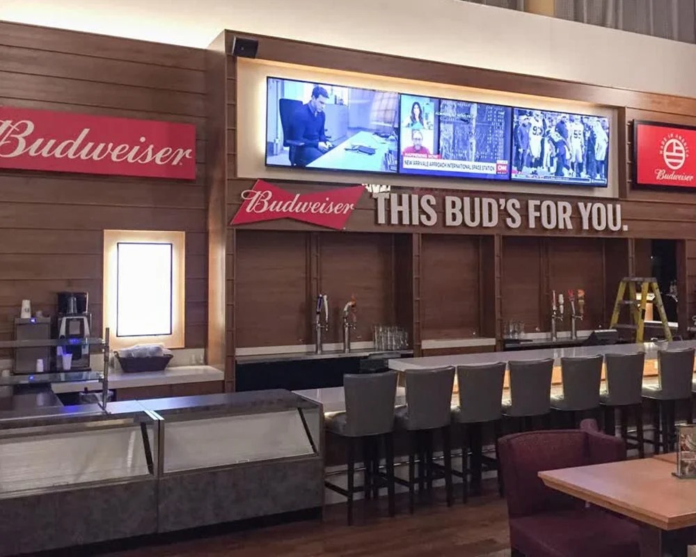 Stadium bar with wood paneling, featuring a Budweiser sign