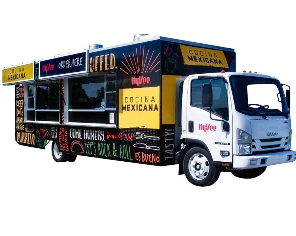 Hy-Vee Cocina Mexicana custom food truck with vibrant black, yellow, and white graphics and hand-lettered designs, built by food truck builders.