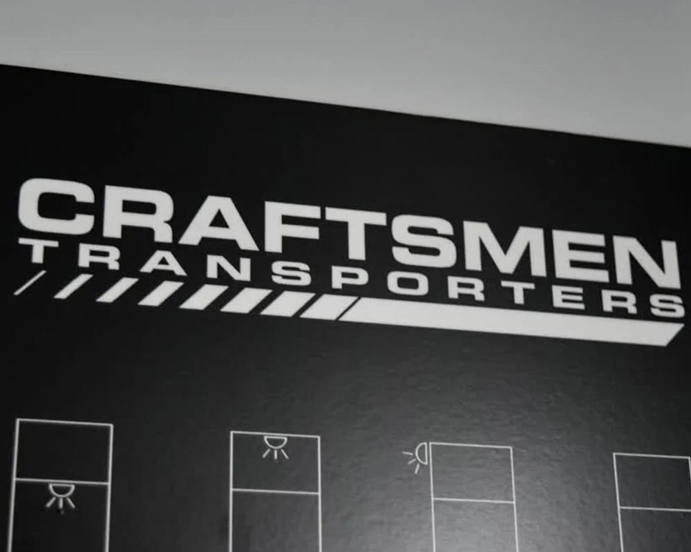 Close up of the Craftsmen Transporters logo on a panel inside a race car trailer