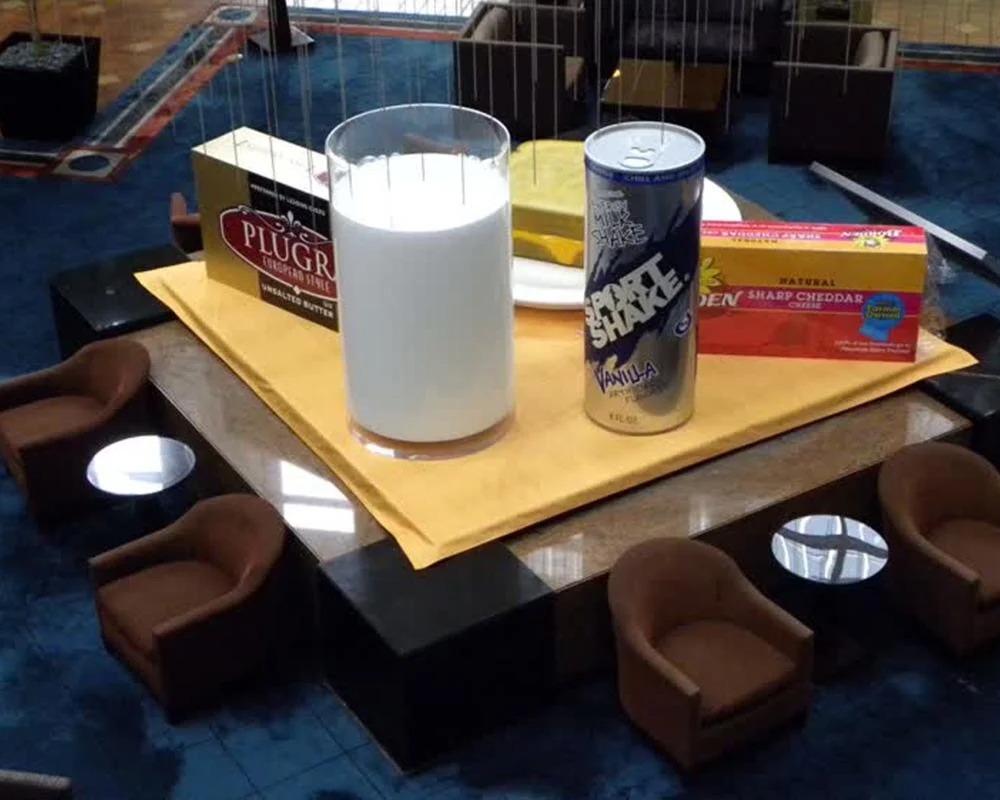 Giant props of milk, Sport Shake, butter, and cheese displayed at a Dairy Farmers of America experiential event.