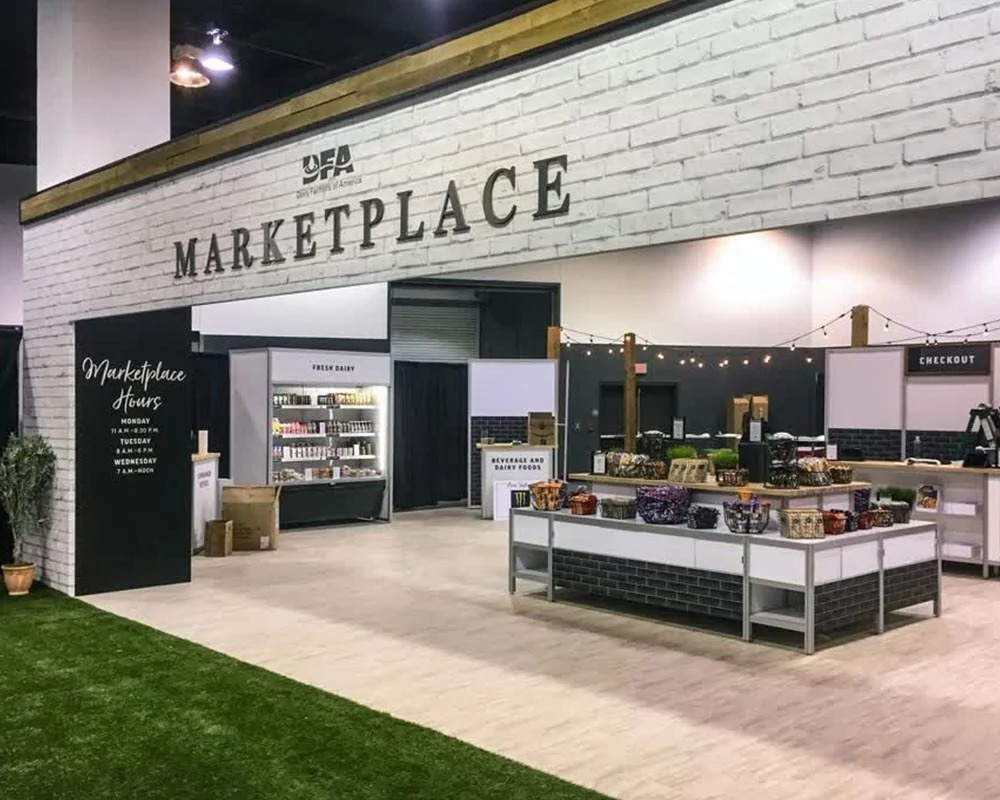 Dairy Farmers of America Marketplace pop-up store with brick archway and display counters at an experiential event.