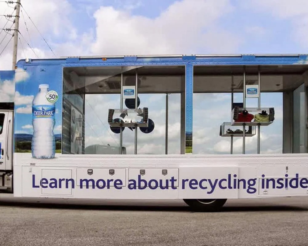 Deer Park Water mobile recycling truck with large windows displaying items made from recycled plastic.