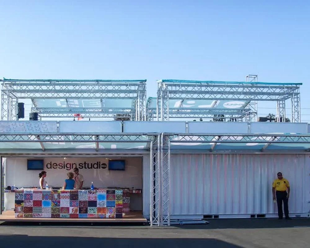 Dell Computers Design Studio shipping container conversion for a mobile experiential bar/lounge with a colorful tiled bar and steel truss roofing.