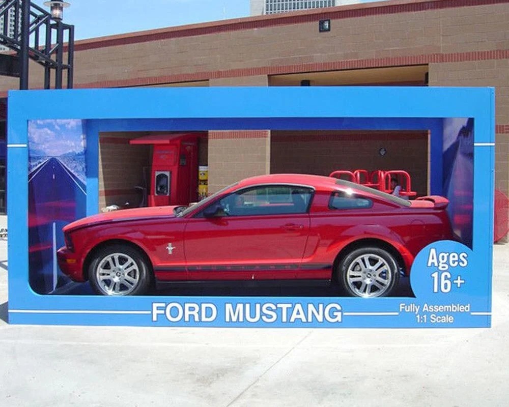 Red Ford Mustang displayed in a life-size toy packaging box for a 1:1 scale experiential event.