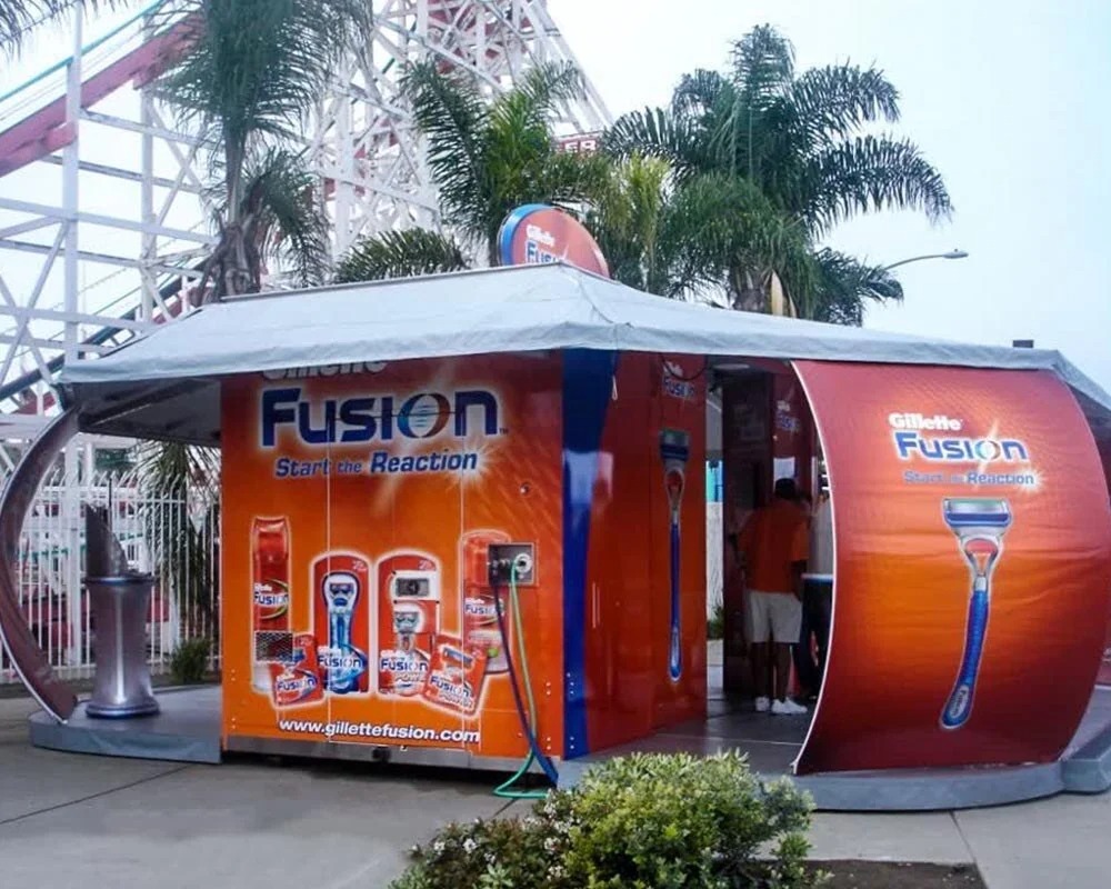 Orange Gillette Fusion mobile showroom pop-up with a large graphic of the razor and the slogan