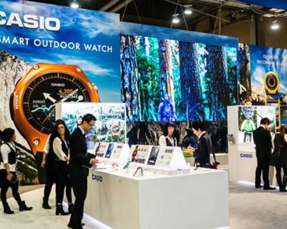 Casio trade show booth featuring a large format backlit wall graphic of a forest and a Casio Smart Outdoor Watch display.