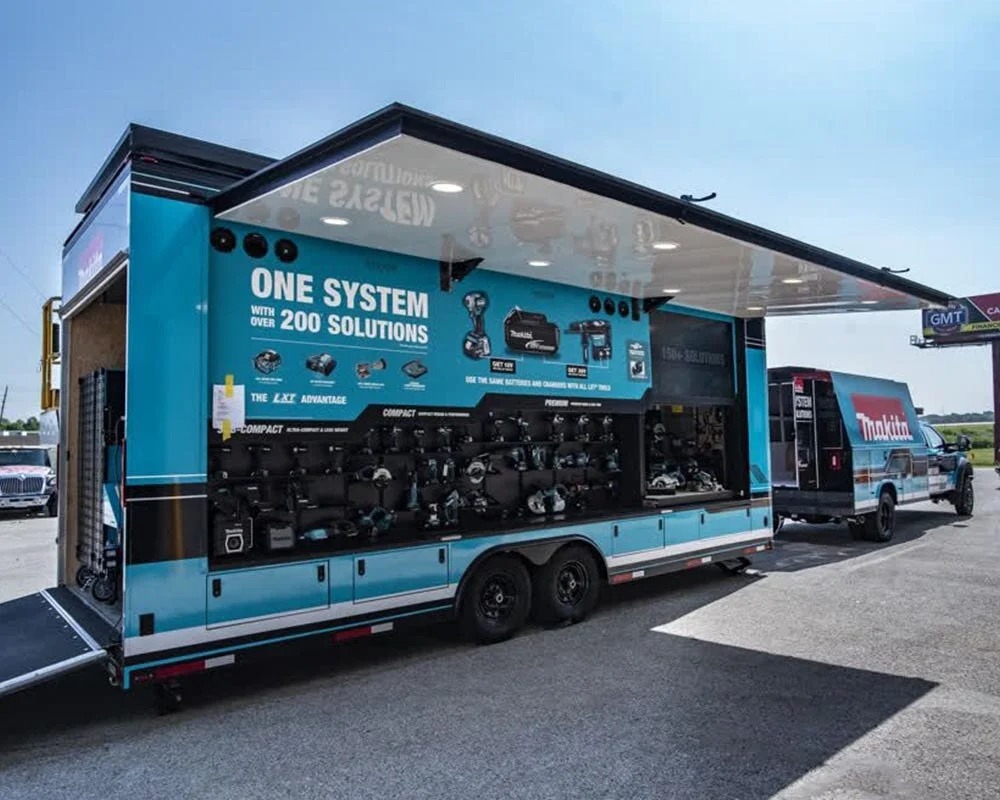 Makita mobile showroom trailer open for display, showing LXT power tools, batteries, and the