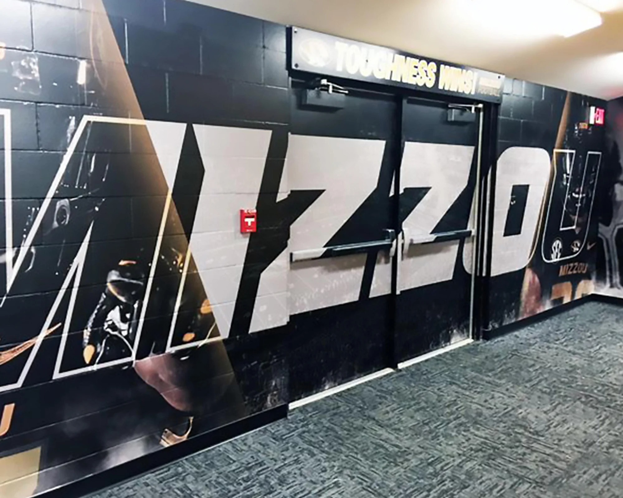 Mizzou Tigers football Toughness Wing custom vinyl graphics on a black and gold hallway wall