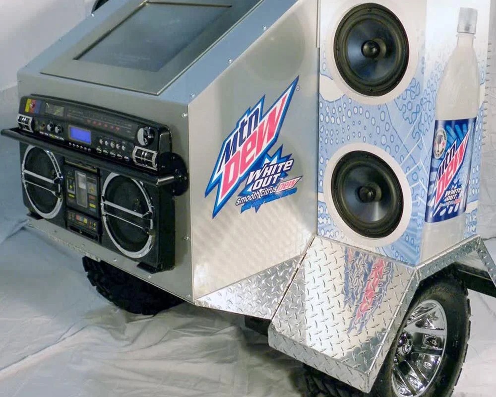 Mountain Dew White Out sound system trailer with boombox, large speakers, and diamond plate finish for an event.