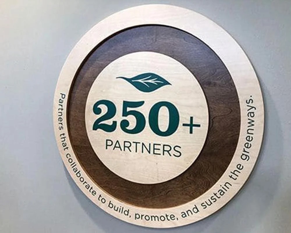 Circular layered wood interior sign for nature conservation partners displaying
