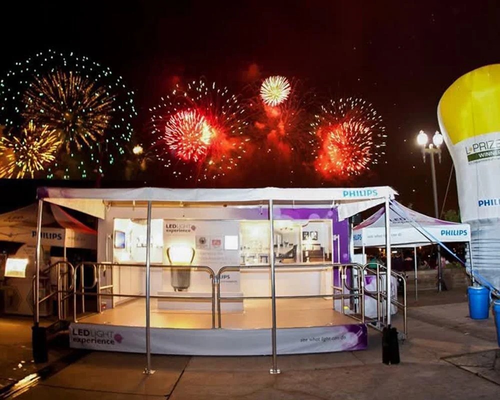 Philips LED Light Experience mobile showroom trailer with an elevated deck at a nighttime event with fireworks overhead.