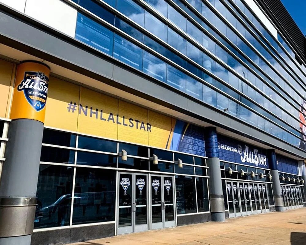 Close-up of custom vinyl window graphics and large format vinyl banner installation on the St. Louis Blues arena for a major NHL event.