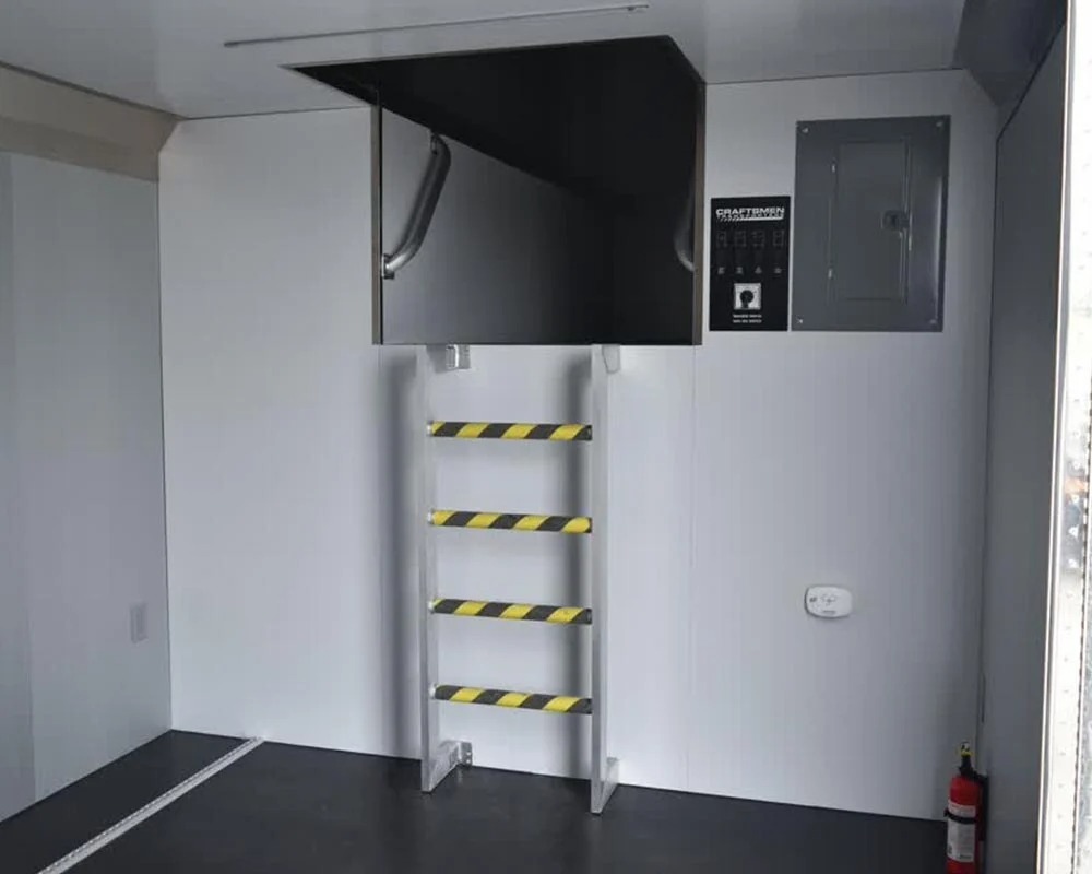 Stock race car trailer interior with ladder to loft area electrical panel and fire extinguisher