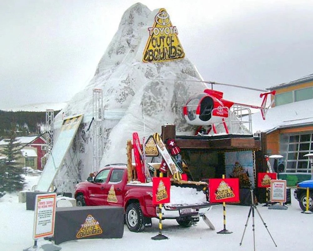 Toyota Out of Bounds winter event with a giant snow mountain, helicopter, and pickup truck display.
