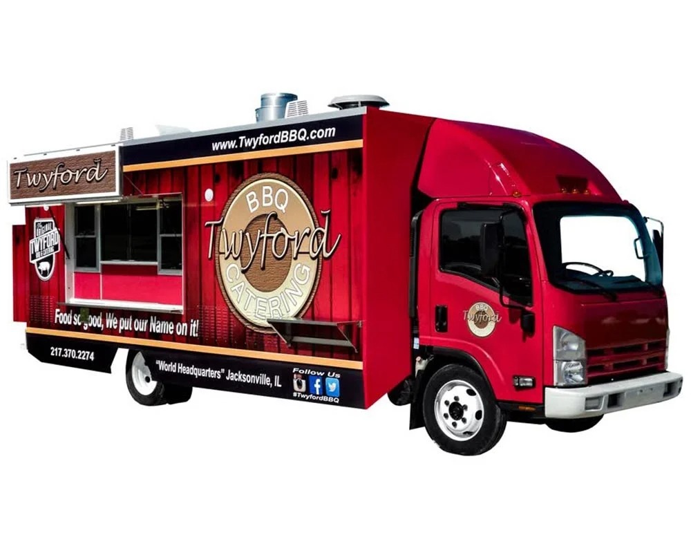 Bright red Twyford BBQ catering custom food truck with a rustic wood-panel graphic wrap, built by professional food truck builders.