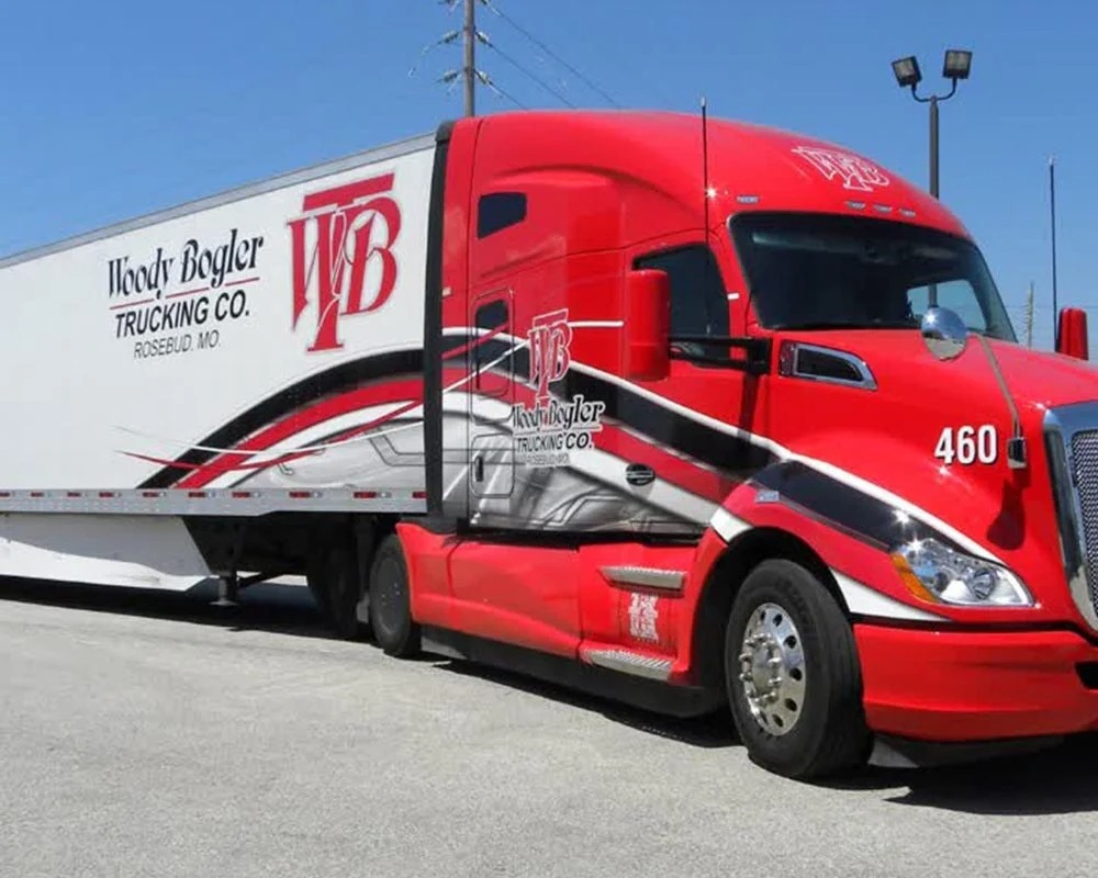 Woody Bogler Trucking Co. mobile billboard truck and trailer with custom red, white, and black graphics and the WB logo.