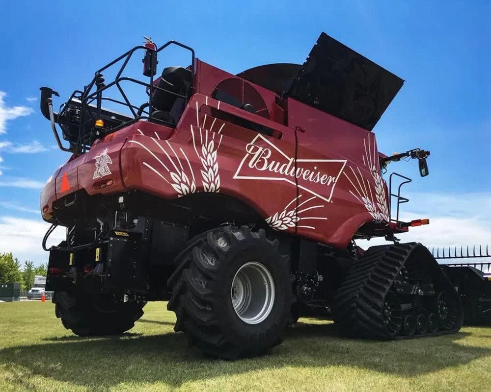 Budweiser-branded agricultural combine featuring durable custom fleet graphics exposed to outdoor weather and field conditions.