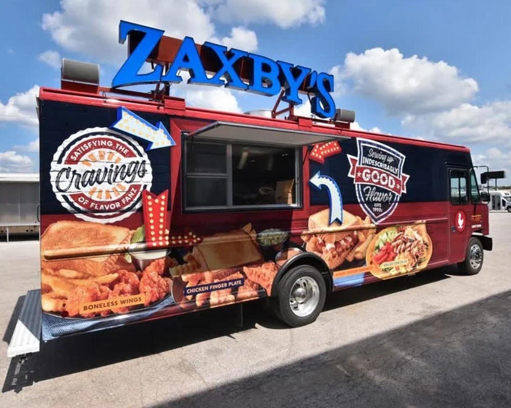 Zaxby’s branded food truck featuring a custom vehicle wrap with chicken wings, sandwiches, fries, and restaurant graphics.